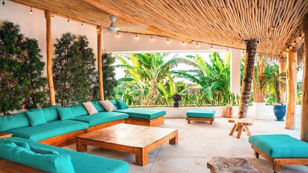 Eine moderne Lounge-Bereich im Freien mit Holzboden, einem großen Ecksofa und einem Couchtisch.