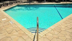 En pool med säkerhetsräcke, kakelbeklädd poolkant och en markering som visar att vattendjupet är 3 fot.