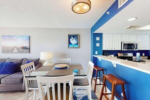 A modern kitchen with white cabinets, a microwave, and a stove. - Bay Watch Resort 1712 (North Myrtle Beach)