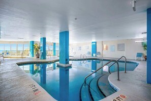 An indoor swimming pool with clear water, blue pillars, and a tiled floor. - Bay Watch Resort 1712 (North Myrtle Beach)