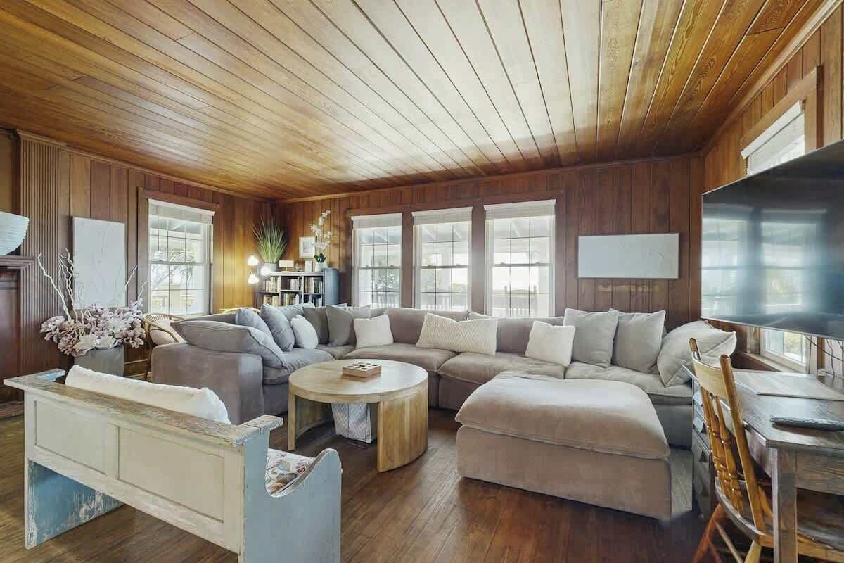 A cozy living room with a sectional sofa, a coffee table, and a television.