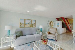 A living room with a sofa, armchairs, a coffee table, and a staircase in the background. - Perfect Harmony Retreat (North Myrtle Beach)