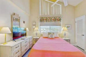 A bedroom with a bed, two bedside tables, a television, and a window with blinds. - Perfect Harmony Retreat (North Myrtle Beach)