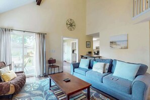 A living room with a sofa, a coffee table, and a dining area. - Cozy Beach Retreat Villa (Myrtle Beach)