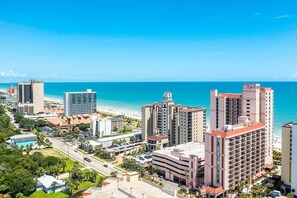 A coastal cityscape with high-rise buildings, a beach, and a clear blue sky. - Golden Mile Condo Retreat (Myrtle Beach)