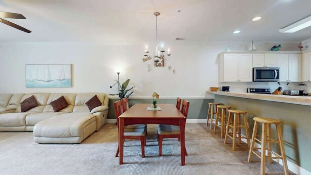 Ein modernes Wohnzimmer mit Sofa, Esstisch und Barhocker.