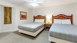 A hotel room with two beds, a ceiling fan, a painting, and a flag on the wall. - The Horizon at 77th Unit 805 (Myrtle Beach)