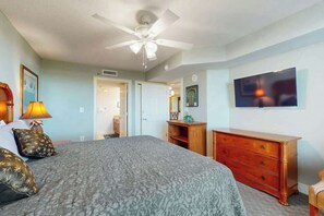 A bedroom with a bed, a ceiling fan, a dresser, and a television on the wall. - The Horizon at 77th Unit 805 (Myrtle Beach)