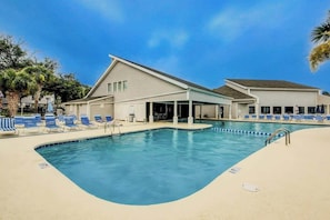 A swimming pool with lounge chairs and a covered area, surrounded by palm trees. - Arcadian Dunes 12-246 (Myrtle Beach)