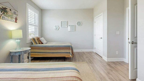 Una camera da letto con due letti, un ventilatore a soffitto e una parete decorata.