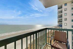 Ein Balkon mit Blick auf Strand und Meer.