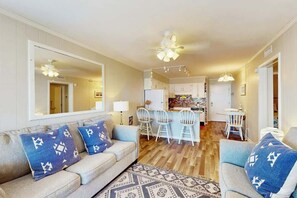 Ein modernes Wohnzimmer mit einer Couch, Sesseln und einem Essbereich mit Tisch und Stühlen.