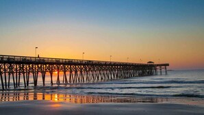 A pier extending into the ocean with a sunset in the background. - A Place at the Beach VI - 305 (Myrtle Beach)