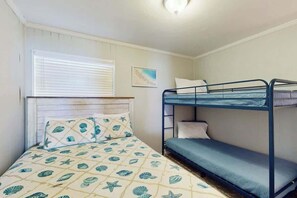 A bunk bed room with a patterned bedspread, a window with blinds, and a wall-mounted light fixture. - A Place at the Beach VI - 305 (Myrtle Beach)