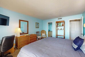 Une chambre à coucher comprenant un lit, un bureau, une chaise, une commode et une armoire.