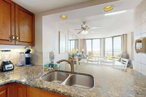 A modern kitchen with granite countertops, stainless steel appliances, and a double sink. - Ocean Creek Plantation D-5 (Myrtle Beach)