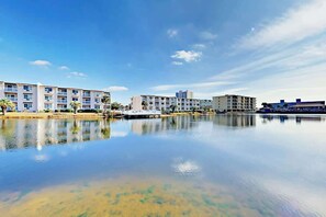 Ein Hotel am Wasserufer mit mehrstöckigen Gebäuden, einer Anlegestelle und ruhigem Gewässer, das die Architektur widerspiegelt.