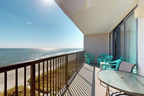 Ein Balkon mit Meerblick, einem Tisch und zwei Stühlen.