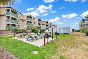 A residential building with multiple balconies, a barbecue area with grills, and a small utility shed. - A Place at the Beach III 2-I (Myrtle Beach)