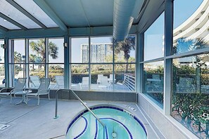 Ein Poolbereich mit Blick auf Palmen und Gebäude.