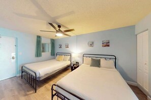 A room with two beds, a ceiling fan, and a door. - Bay Watch Resort 0834 (North Myrtle Beach)