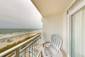 A balcony with a view of the beach and a pool area. - Bay Watch Resort 0834 (North Myrtle Beach)