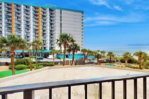 Ein Hotel mit mehreren Etagen, einem Poolbereich und Blick auf den Strand.