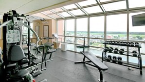 Ein Fitnessraum mit Trainingsgeräten, einer Bank und einem Dumbbell-Gestell.