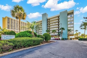 A hotel with a sign reading 'Carolina Dunes,' featuring a modern building with multiple floors and a parking area. - Carolina Dunes Unit 603 (Myrtle Beach)