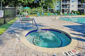 A hot tub with a 3 FT depth marker, surrounded by lounge chairs and a pool. - Coastal Charm Unit 2G (Myrtle Beach)