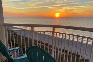 Ein Balkon mit Blick auf den Sonnenuntergang über dem Meer.