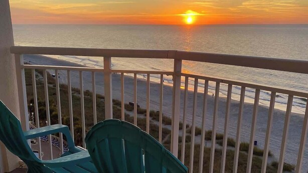 Ein Balkon mit Blick auf das Meer bei Sonnenuntergang.