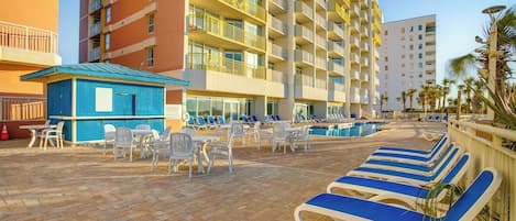 A hotel pool area with lounge chairs, a small blue structure, and a pool.