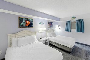 A hotel room with two beds, a nightstand with a lamp, and artwork on the walls. - Bay Watch Resort 0533 (North Myrtle Beach)