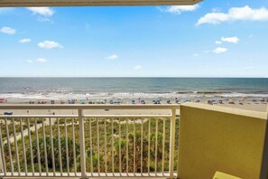 A balcony with a view of a beach, palm trees, and the ocean. - Bay Watch Resort 0504 (North Myrtle Beach)