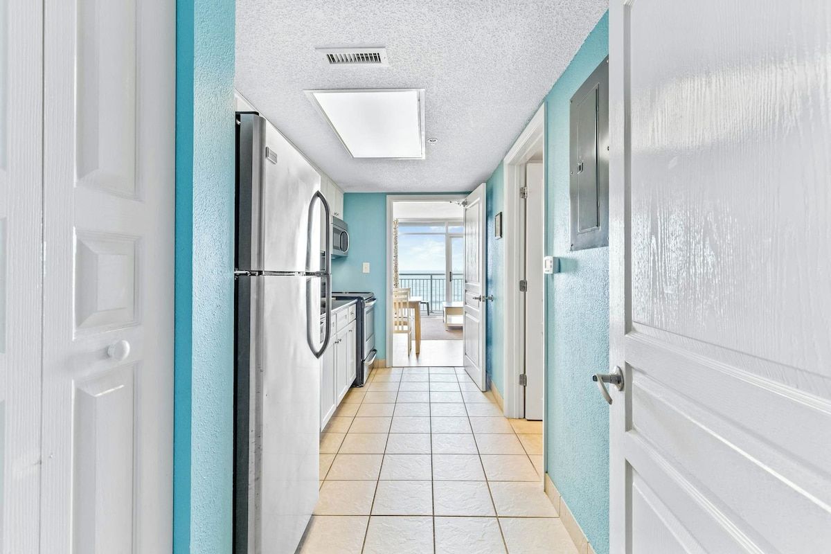 Un pasillo con una zona de cocina, microondas y vista al exterior.