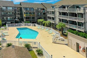 A hotel with a swimming pool, multiple balconies, and a fenced deck area. - Shipwatch Pointe I - J329 (Myrtle Beach)