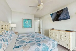 A bedroom with a bed, a dresser, a television mounted on the wall, and a painting. - North Beach Towers 213 (North Myrtle Beach)