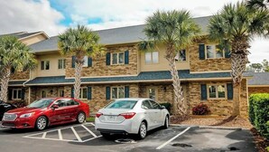 A two-story building with a parking lot in front. - Eagle Haven H1 Condo (Myrtle Beach)