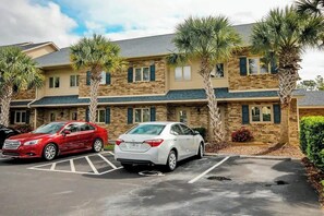 A two-story building with a parking lot in front. - Eagle Haven H1 Condo (Myrtle Beach)