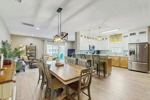 A spacious kitchen with a dining area, wooden furniture, and modern appliances. - Hawleywood Beach Retreat (Surfside Beach)