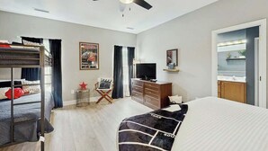 Ein Hotelzimmer mit Stockbett, Schreibtisch mit Stuhl, Fernseher und Kleiderschrank.