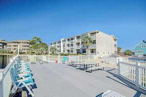 A waterfront hotel with a poolside area, multiple balconies, and a view of the water. - Beach Cottages at OD - 33B (North Myrtle Beach)