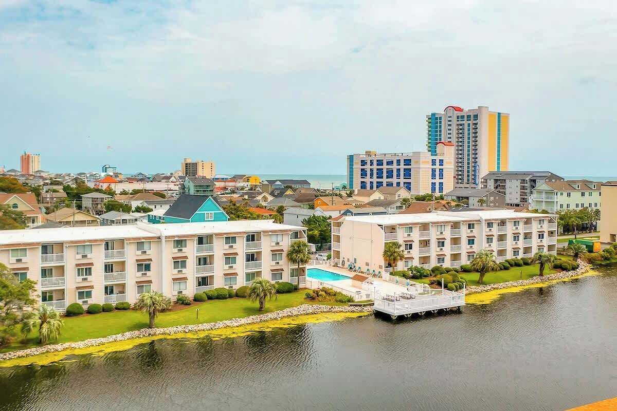 Un hôtel à plusieurs étages, doté d’une piscine et d’un quai.