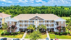 A multi-story hotel with a central courtyard, balconies, and a parking area. - The Havens Unit 1721 (North Myrtle Beach)