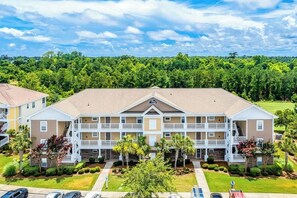 A multi-story hotel with a central courtyard, balconies, and a parking area. - The Havens Unit 1721 (North Myrtle Beach)