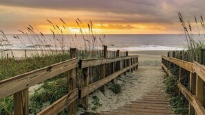 A wooden boardwalk leading to a beach with overcast skies. - The Havens Unit 1721 (North Myrtle Beach)