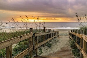 A wooden boardwalk leading to a beach with overcast skies. - The Havens Unit 1721 (North Myrtle Beach)