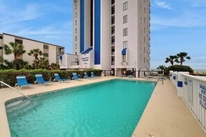 A swimming pool with lounge chairs and a building labeled 'Crescent Towers' in the background. - Crescent Towers I - 102 (North Myrtle Beach)