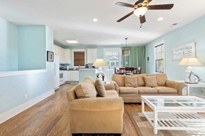 A spacious living area with a sofa, coffee table, and a ceiling fan. - Madiera Magic Retreat (North Myrtle Beach)